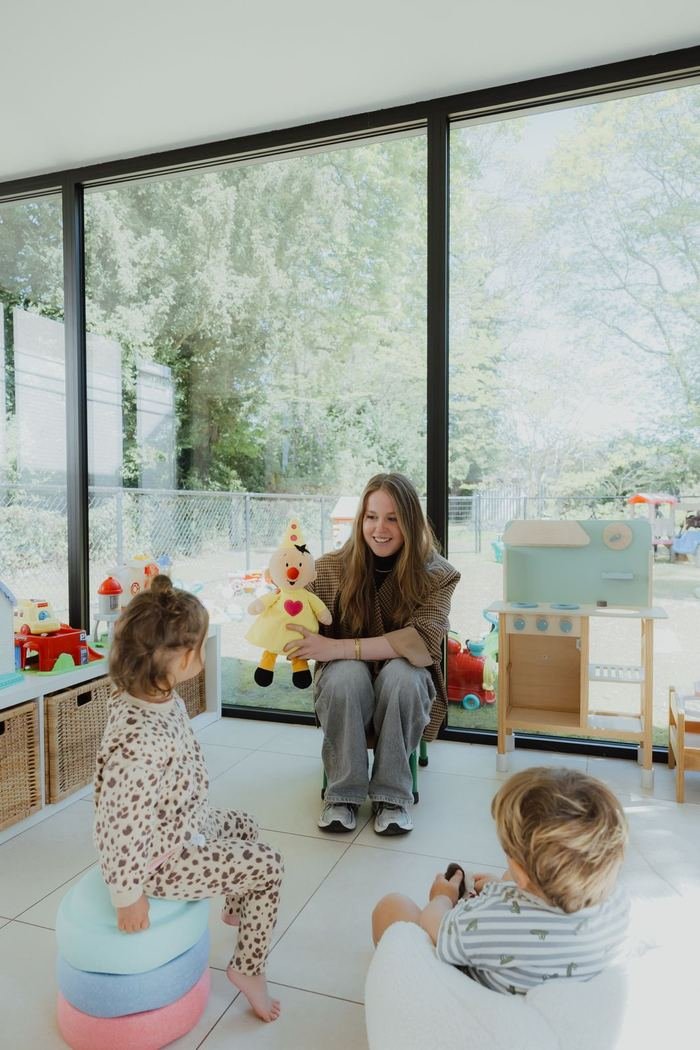 Begeleidster speelt samen met de kindjes