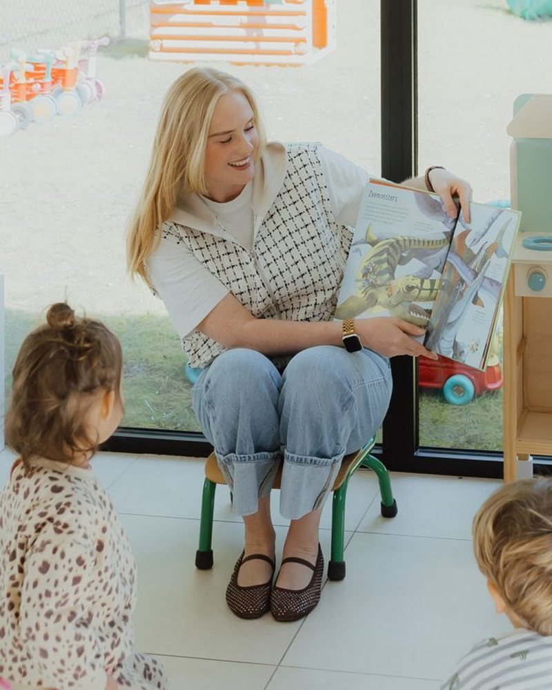 Begeleidster speelt samen met kindjes in de leefruimte van Het Venneke